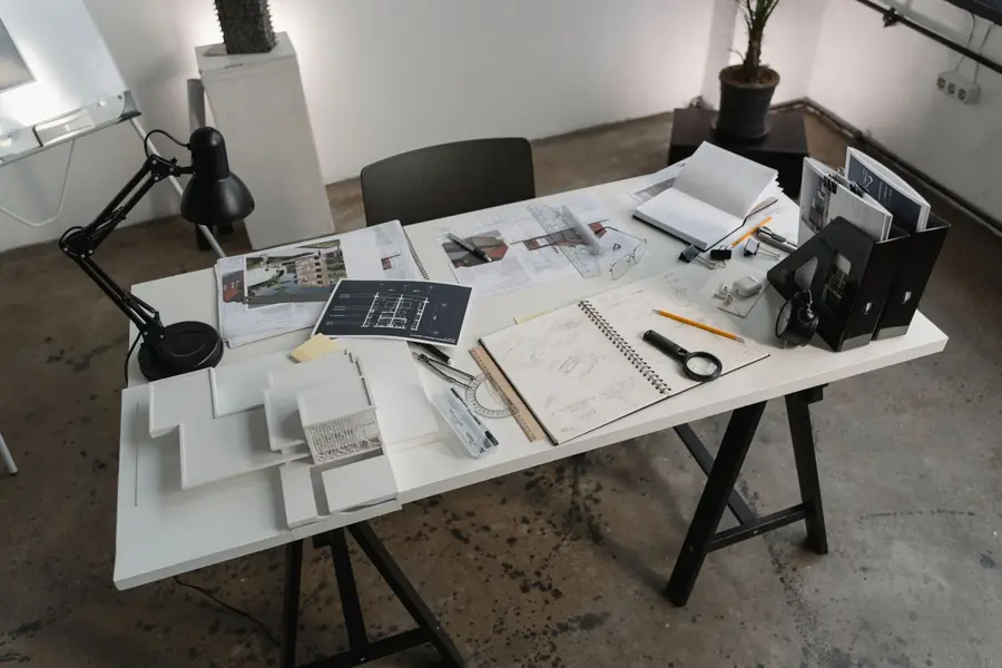 A creative workspace with architectural tools, blueprints, and sketches for design projects.