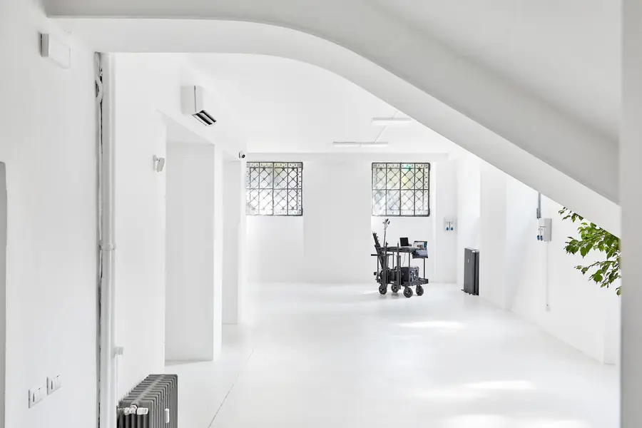 Bright minimalist interior space with white walls and modern equipment cart.